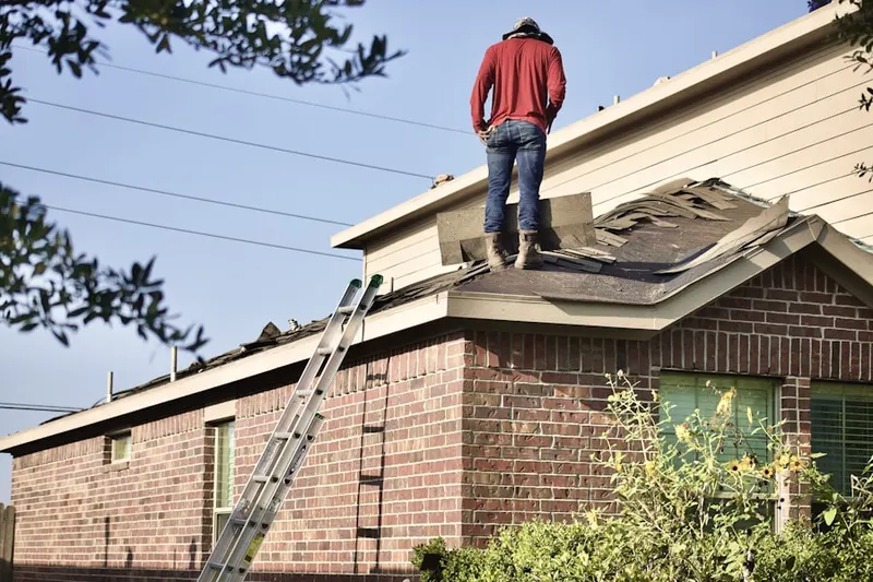 Professional roofer working on a residential roof in Haslet